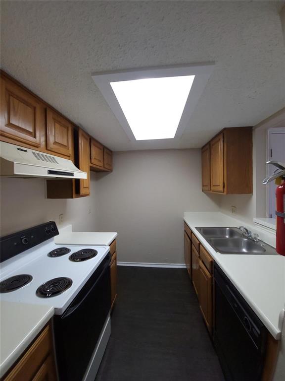 8005 Rothington Road, Unit 57 Dallas, TX 75227 - Photo 6 of 15 Kitchen featuring electric range oven, brown cabinetry, light countertops, and a textured ceiling
