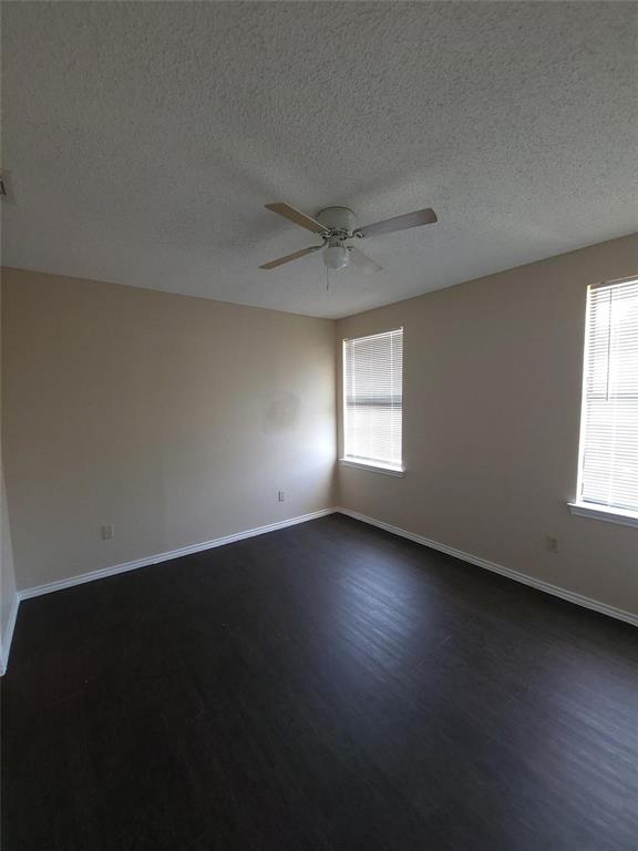 8005 Rothington Road, Unit 57 Dallas, TX 75227 - Photo 7 of 15 Spare room with dark wood-type flooring, a textured ceiling, and ceiling fan