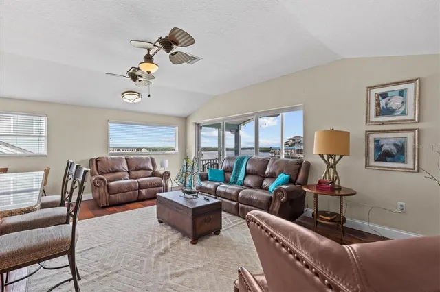 a kitchen with stainless steel appliances granite countertop a refrigerator a sink dishwasher a stove and white countertops with wooden floor