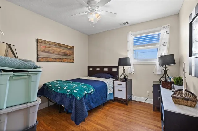 a bedroom with a bed and wooden floor