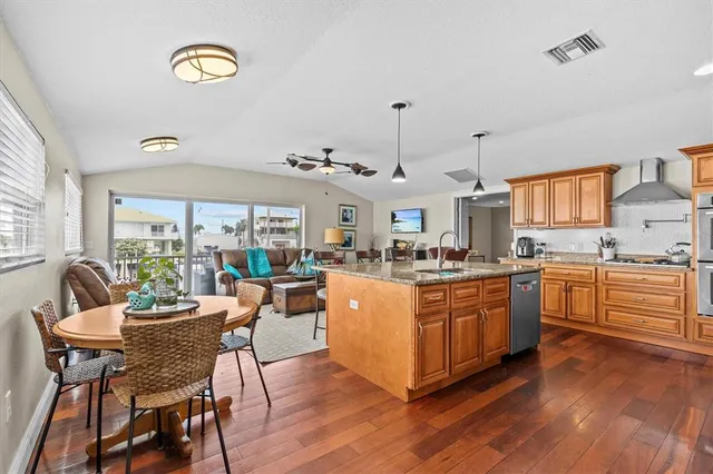 a kitchen with stainless steel appliances granite countertop a sink and wooden floor