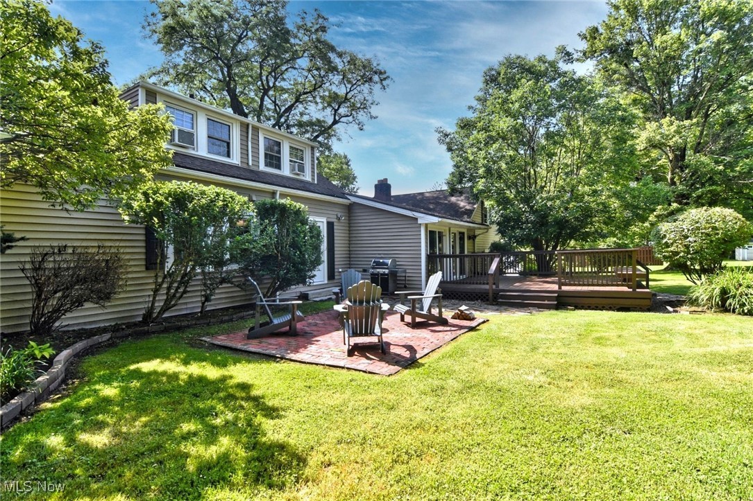5876 Som Center Road Solon, OH 44139 - Photo 29 of 30 Back of house featuring a patio area, a wooden deck, and a lawn