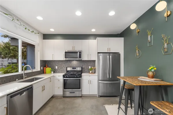 a kitchen with a sink stainless steel appliances and window