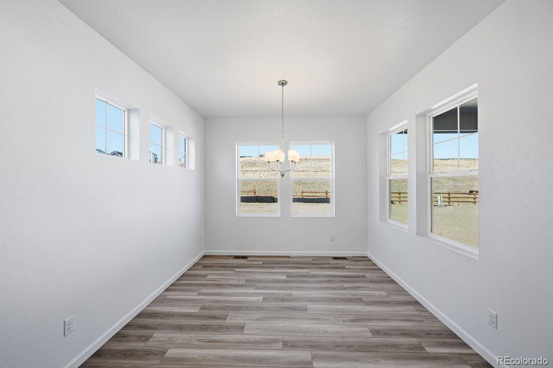 39803 Penn Road Elizabeth, CO 80107 - Photo 14 of 43 an empty room with wooden floor and windows