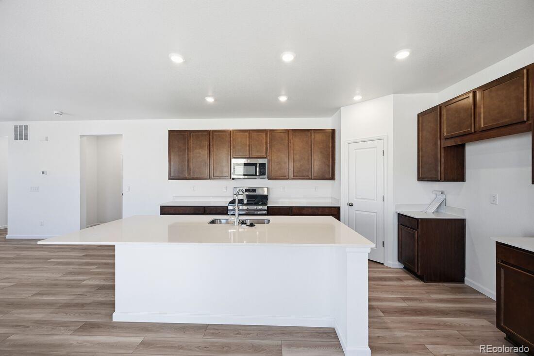 39803 Penn Road Elizabeth, CO 80107 - Photo 8 of 43 a large white kitchen with stainless steel appliances
