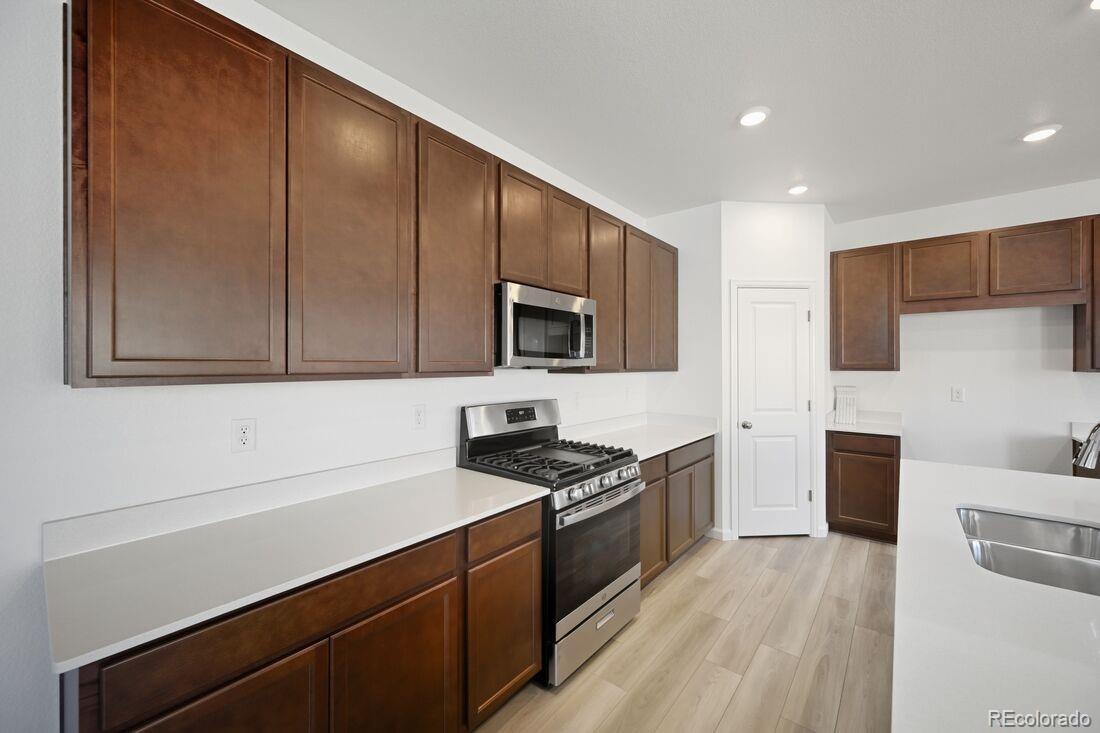 39803 Penn Road Elizabeth, CO 80107 - Photo 10 of 43 a kitchen with stainless steel appliances granite countertop a sink stove and microwave
