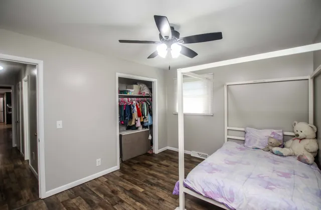 a bedroom with a bed and a ceiling fan