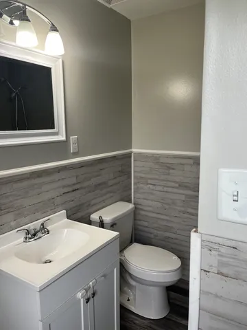 a bathroom with a toilet sink and mirror