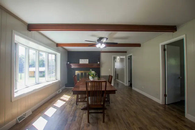 a dining room with furniture a chandelier and wooden floor