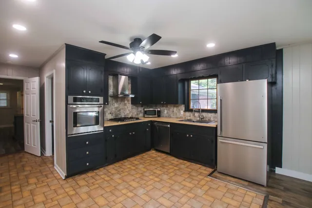 a kitchen with granite countertop stainless steel appliances and a refrigerator