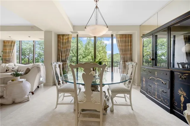 a dining room with furniture water view and a floor to ceiling window