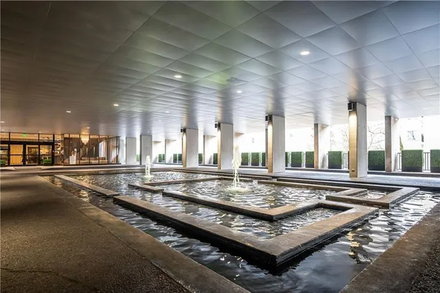 a living room with hard wood floor and large windows