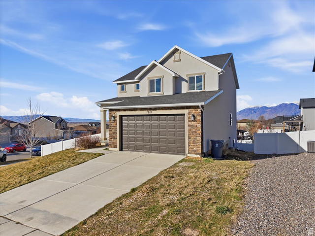 1218 Moonlight Drive Elk Ridge, UT 84651 - Photo 3 of 44 Traditional home with stucco siding, concrete driveway, stone siding, a mountain view, and a residential view