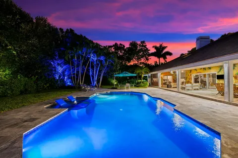 a view of a white house with a yard and plants