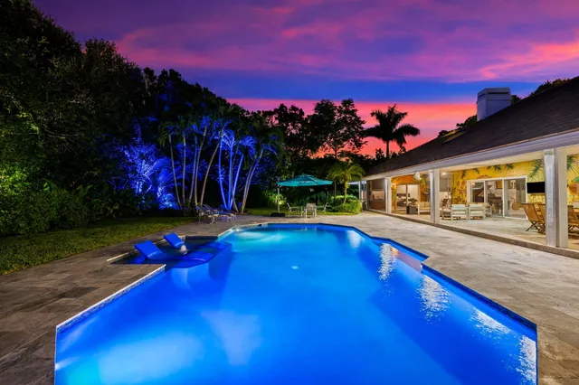 a view of a white house with a yard and plants