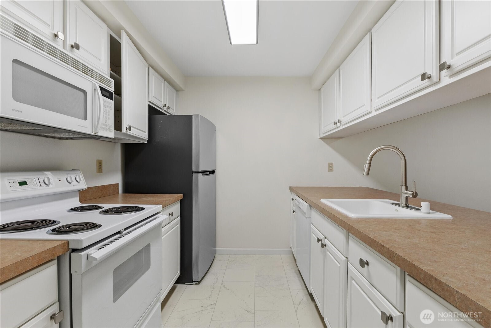 132 Northeast 95th Street, Unit B309 Seattle, WA 98115 - Photo 12 of 24 a kitchen with stainless steel appliances granite countertop a sink stove and refrigerator