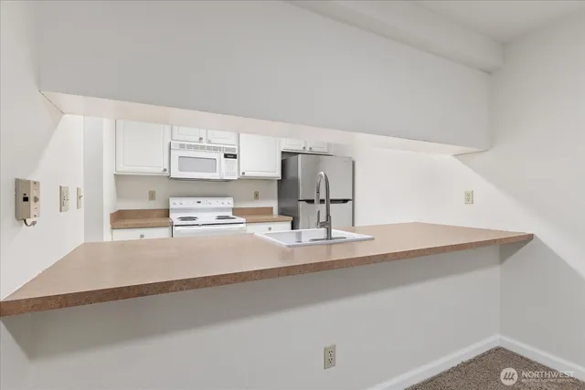 a kitchen with kitchen island a sink stove and refrigerator