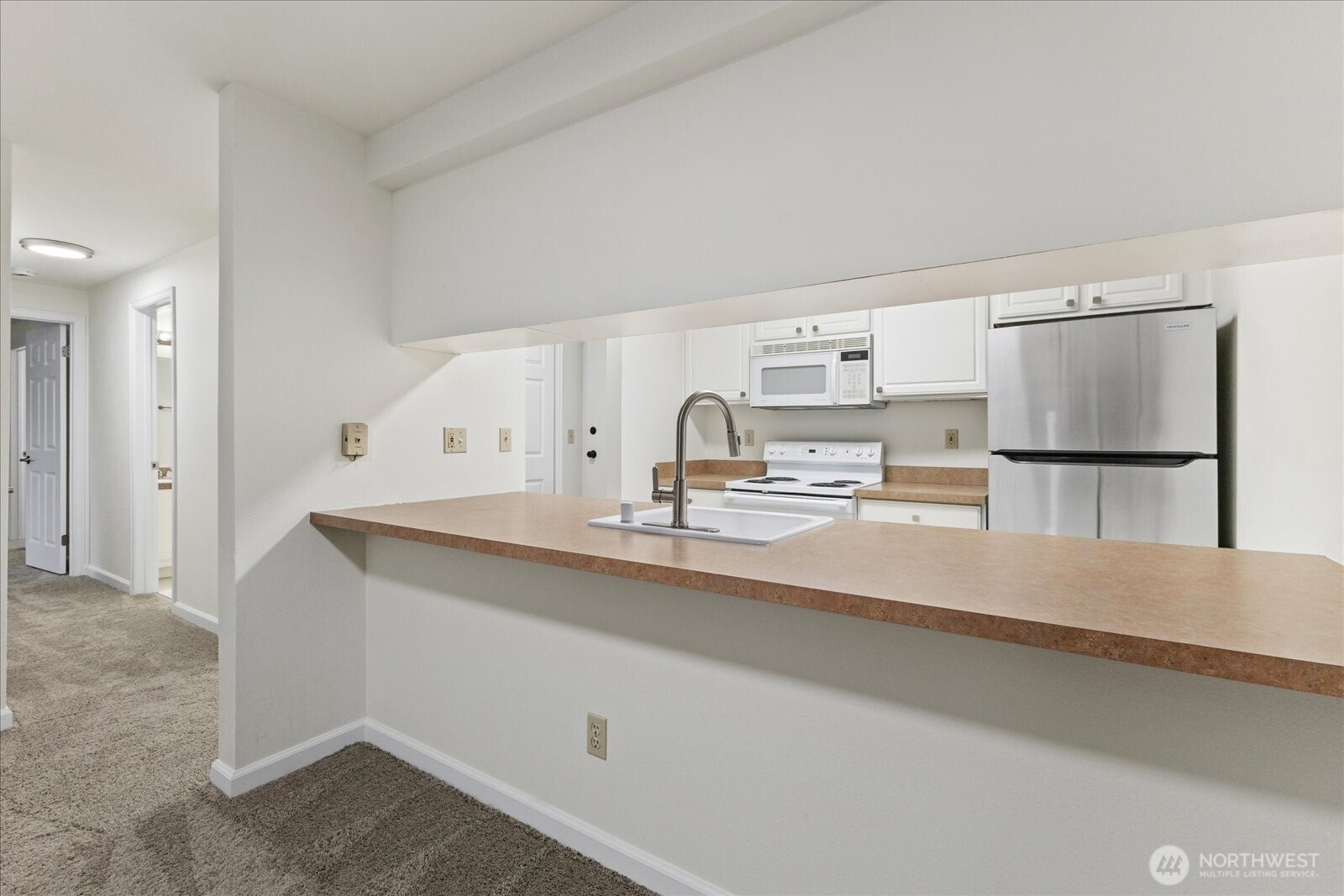 132 Northeast 95th Street, Unit B309 Seattle, WA 98115 - Photo 10 of 24 a kitchen with kitchen island a sink stove and refrigerator