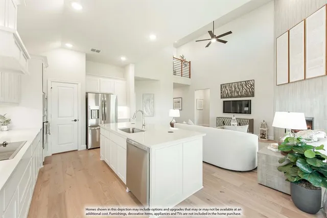 a large white kitchen with stainless steel appliances kitchen island granite countertop a refrigerator and a sink