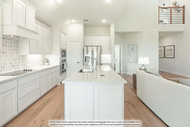 a large white kitchen with sink and cabinets