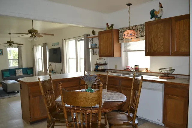a kitchen with granite countertop a sink dining table and chairs