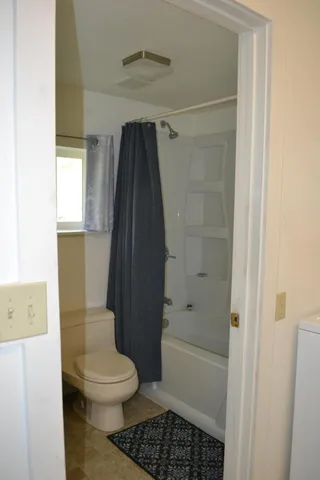 a bathroom with a toilet and a shower