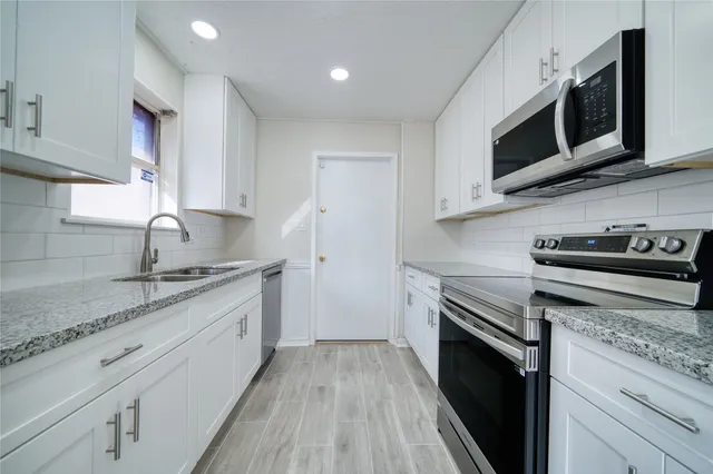 a kitchen with stainless steel appliances granite countertop a sink and a stove