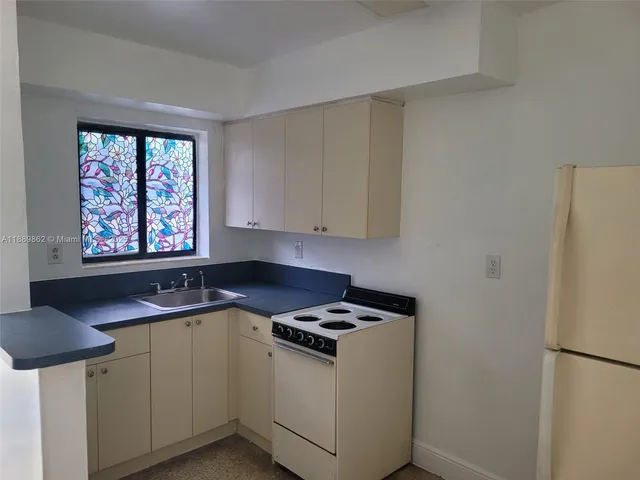 a kitchen with a sink cabinets and a window