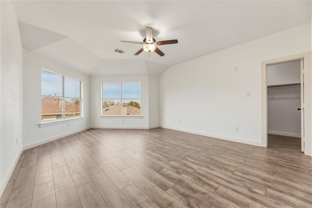 9808 Rockledge Road Fort Worth, TX 76108 - Photo 15 of 30 an empty room with wooden floor chandelier fan and windows