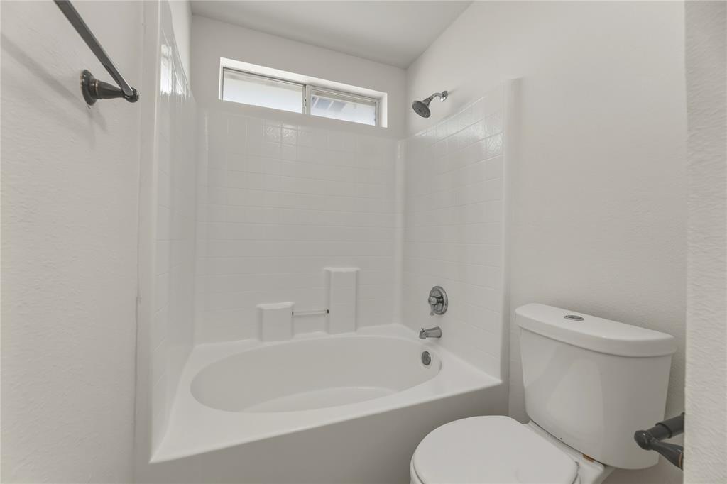 9808 Rockledge Road Fort Worth, TX 76108 - Photo 18 of 30 a white toilet sitting next to a bath tub