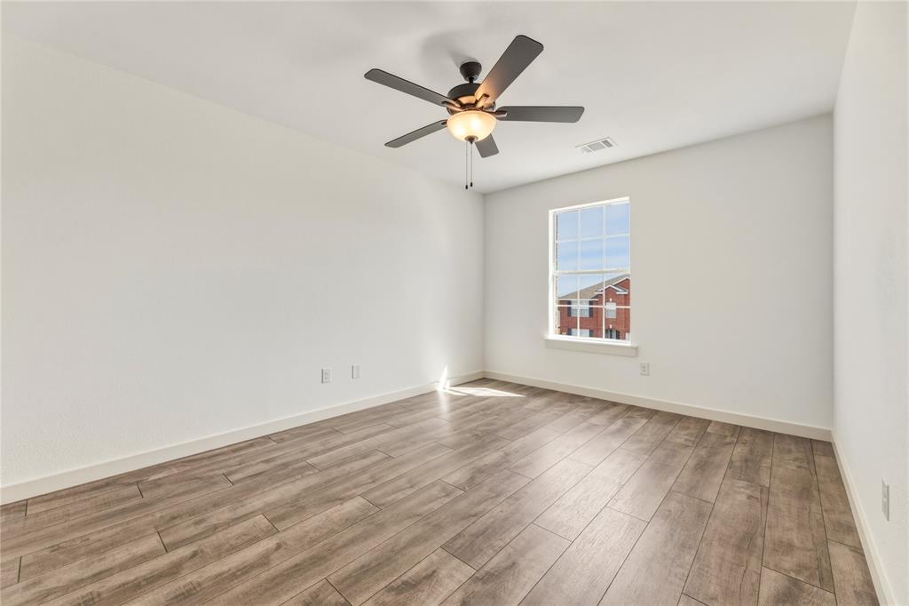 9808 Rockledge Road Fort Worth, TX 76108 - Photo 23 of 30 an empty room with wooden floor and ceiling fan