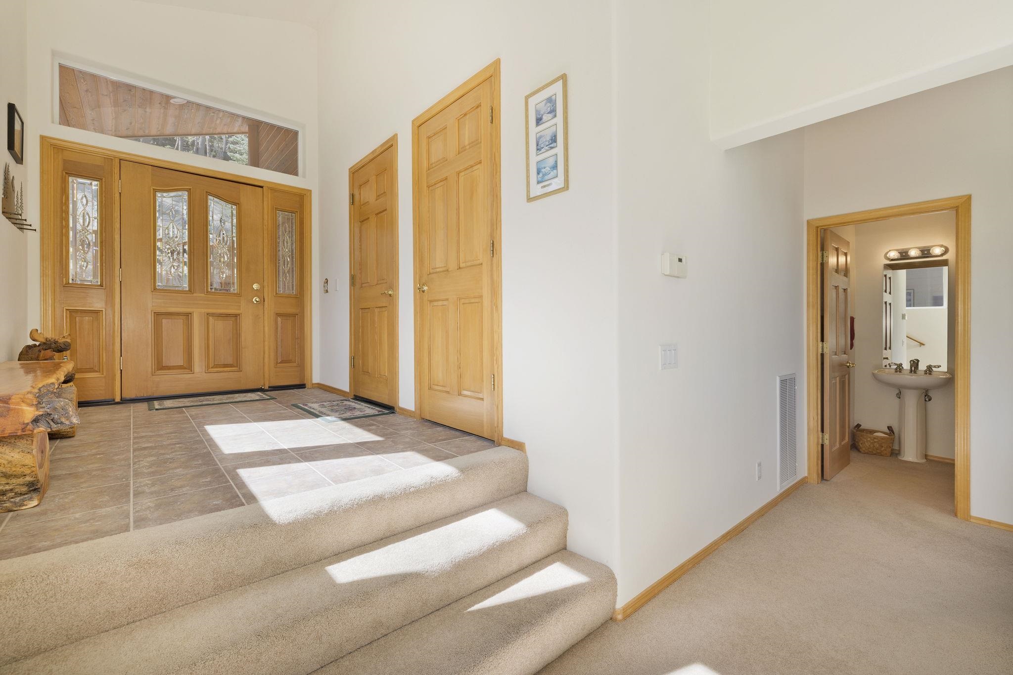 492 John Muir Road Mammoth Lakes, CA 93546 - Photo 3 of 33 Entryway with wood-finish double doors featuring decorative glass panels and an overhead transom window