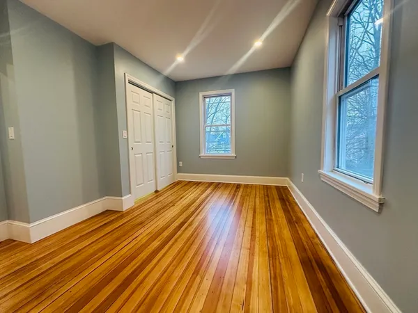 a view of a room with wooden floor and windows