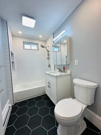 a bathroom with a granite countertop toilet sink and mirror