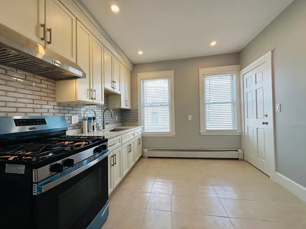 a kitchen with stainless steel appliances a stove a sink and a counter top space