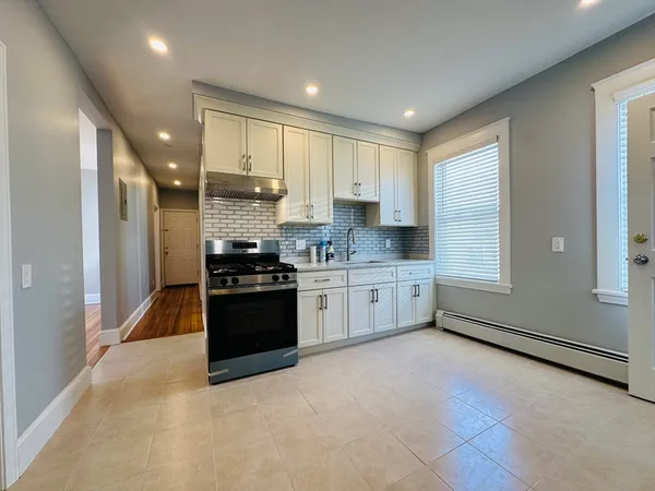 a kitchen with stainless steel appliances kitchen island granite countertop a stove a sink and a refrigerator