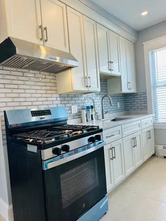 a kitchen with a stove and white cabinets