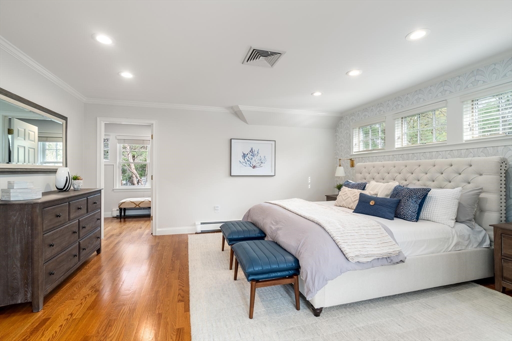 4 Pond Brook Circle Weston, MA 02493 - Photo 16 of 35 a spacious bedroom with a large bed and a wooden floor