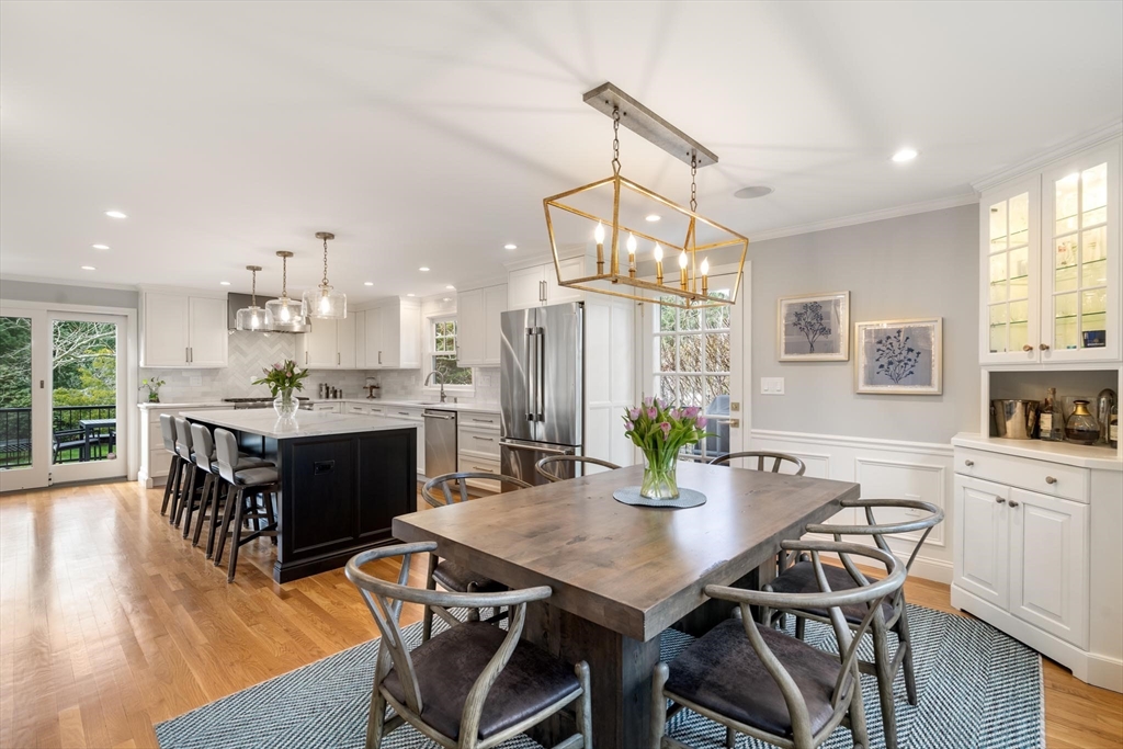 4 Pond Brook Circle Weston, MA 02493 - Photo 10 of 35 a kitchen with stainless steel appliances kitchen island granite countertop a dining table chairs and white cabinets