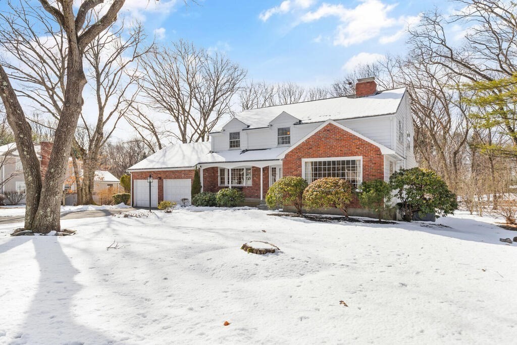 a front view of a house with a yard covered in snow