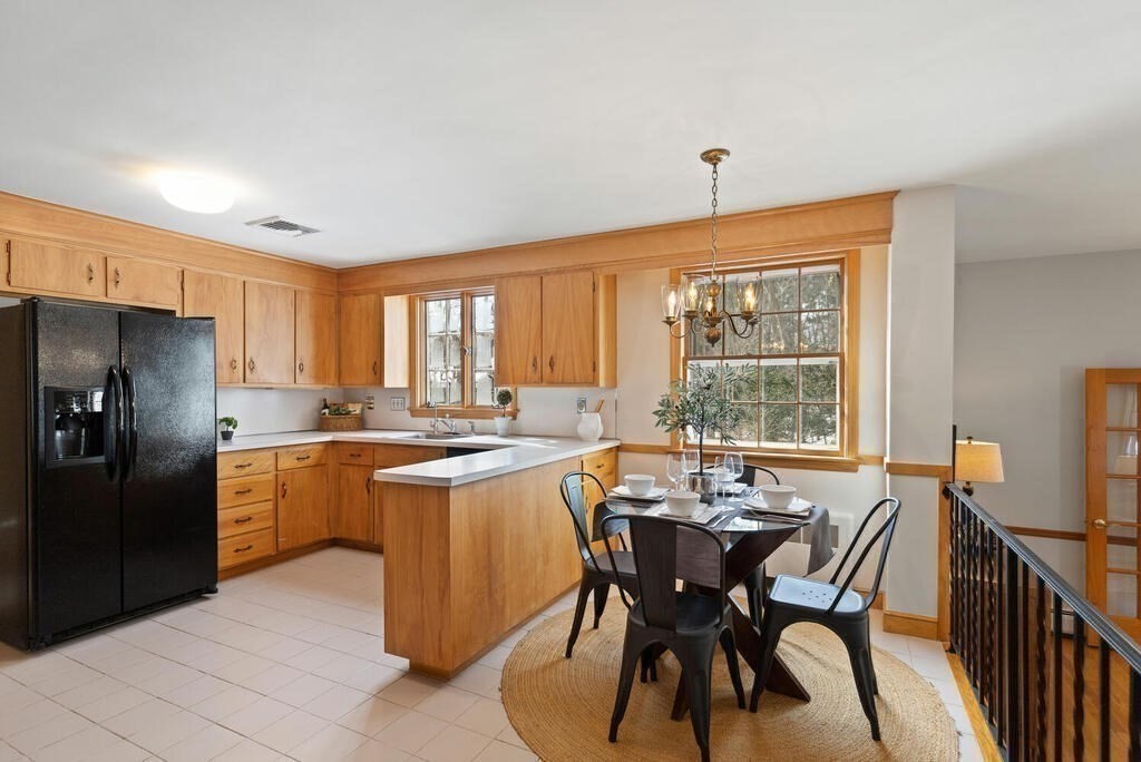 73 Thornberry Road Winchester, MA 01890 - Photo 11 of 39 a kitchen with a dining table chairs and refrigerator