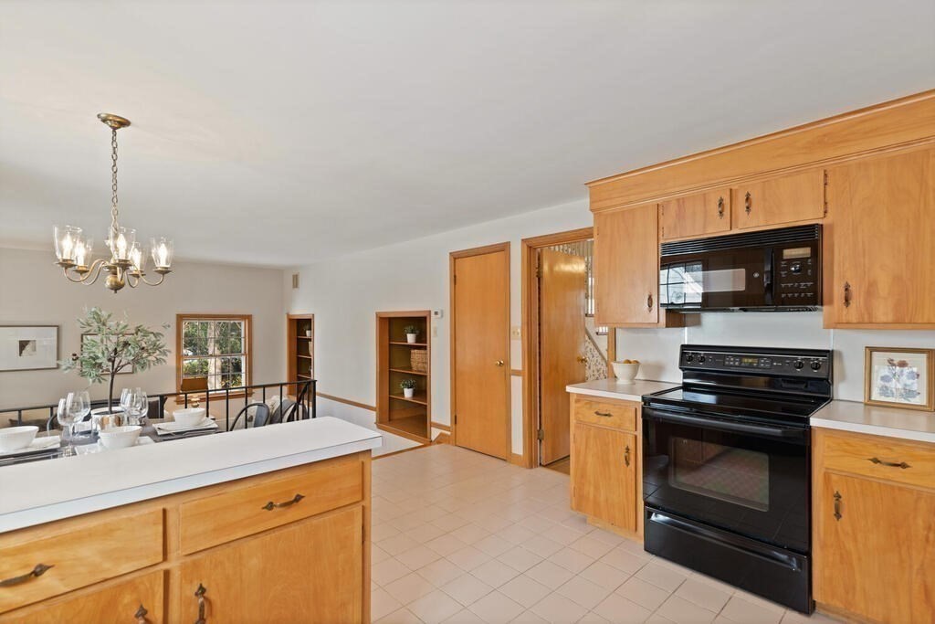 73 Thornberry Road Winchester, MA 01890 - Photo 14 of 39 a kitchen with stainless steel appliances kitchen island granite countertop a stove a sink and a microwave