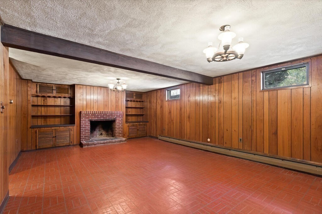 73 Thornberry Road Winchester, MA 01890 - Photo 30 of 39 an empty room with a fireplace cabinet and windows