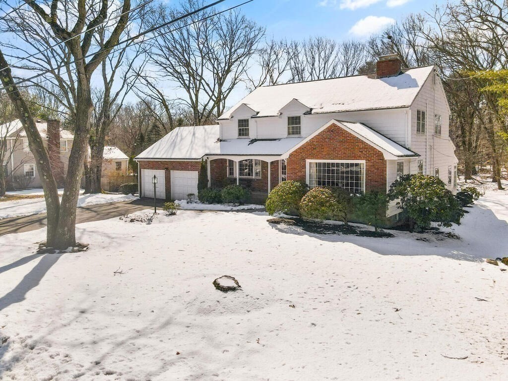 73 Thornberry Road Winchester, MA 01890 - Photo 4 of 39 a view of a white house with a yard covered in snow