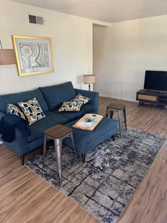 a living room with furniture and a wooden floor
