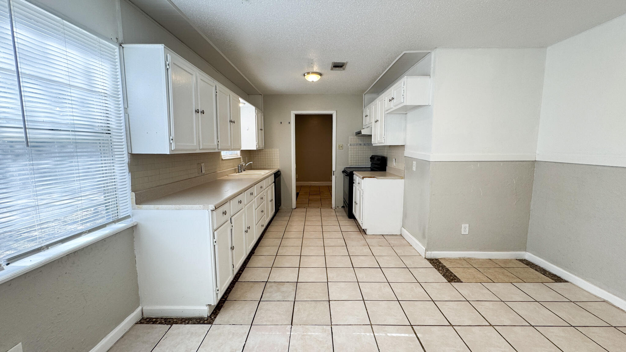 4825 53rd Street Lubbock, TX 79414 - Photo 3 of 13 a kitchen with a sink a stove and cabinets