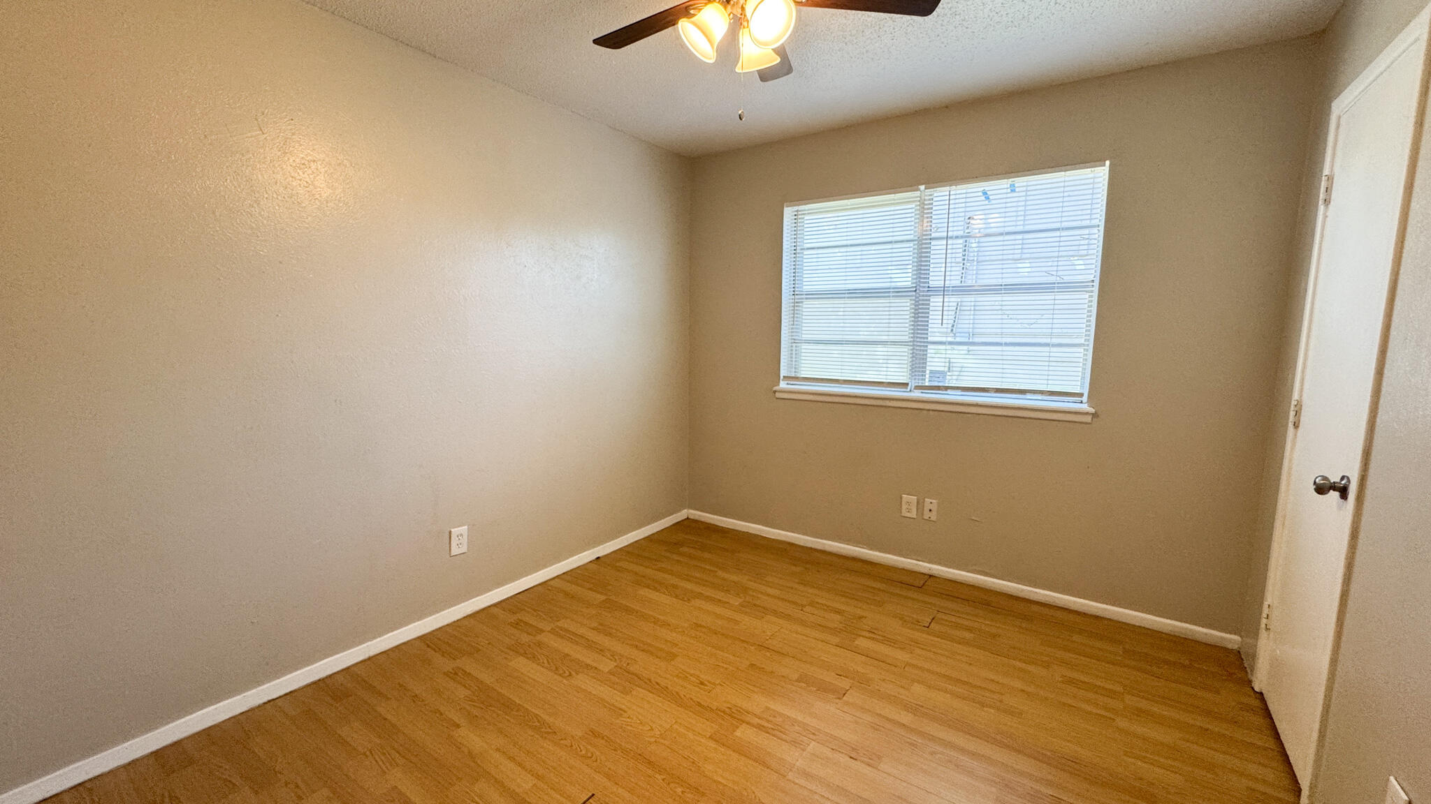 4825 53rd Street Lubbock, TX 79414 - Photo 8 of 13 an empty room with a chandelier fan and windows
