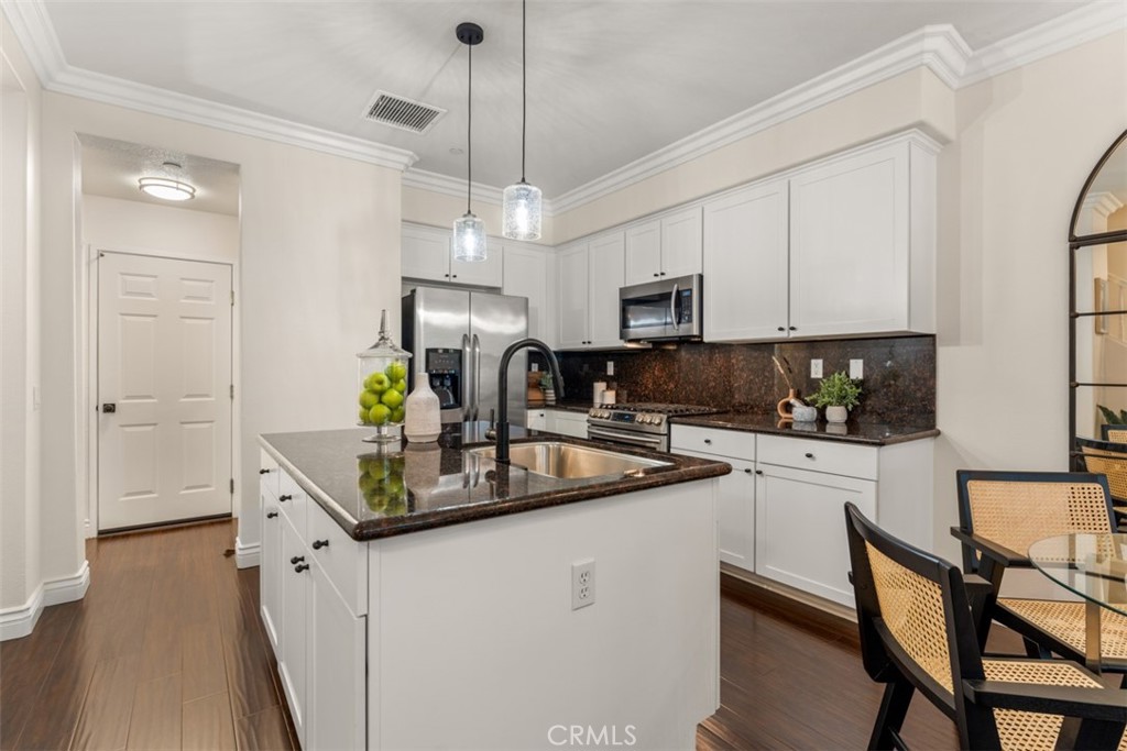 46 Platinum Circle Ladera Ranch, CA 92694 - Photo 8 of 37 a kitchen with stainless steel appliances granite countertop a sink a stove a refrigerator a center island with wooden floor and cabinets