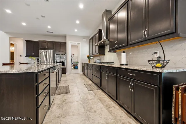 a kitchen with stainless steel appliances granite countertop a sink a stove and a refrigerator