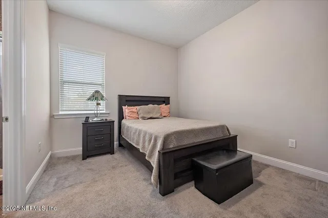 a bed sitting in a bedroom next to a window